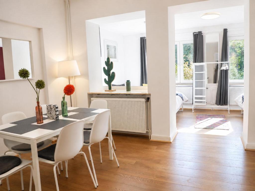 un comedor con una mesa y sillas blancas en The garden flat, en Luxemburgo