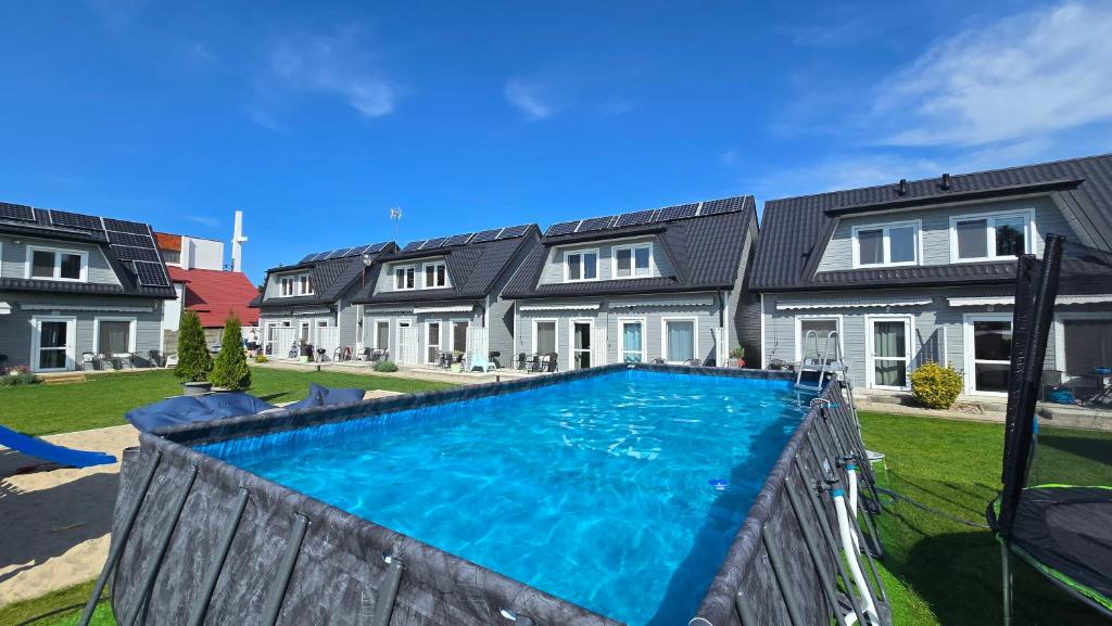 a house with a swimming pool in the yard at Przystań Dziwnówek in Dziwnówek