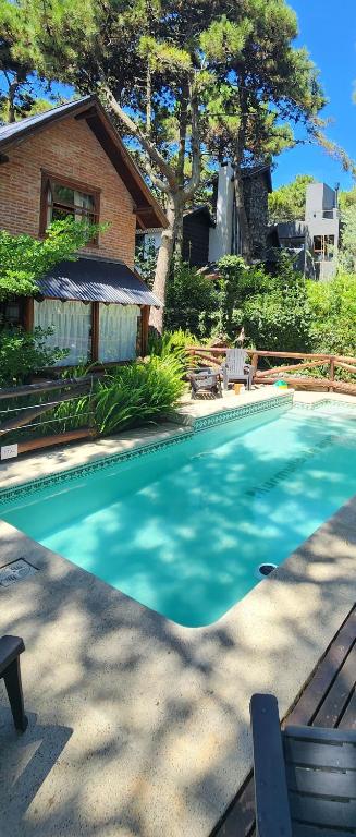 a swimming pool in front of a house at Cabañas Murmullo de Agua in Mar de las Pampas