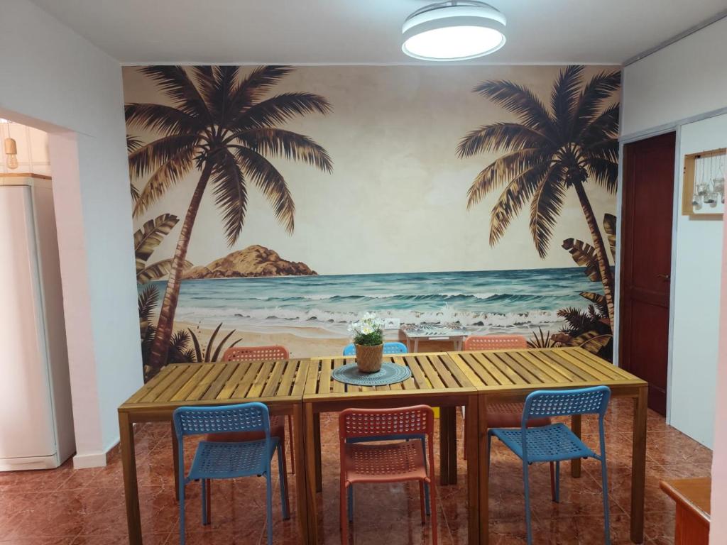 a dining room with a palm tree mural on the wall at Hostel Banana Surf House in Los Cristianos