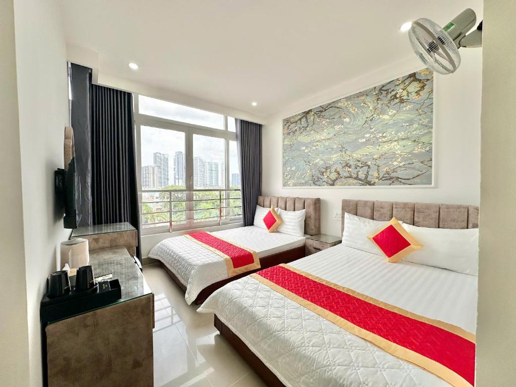 a bedroom with two beds and a large window at Phú Gia Hotel 464 Nguyễn Văn Linh in Ho Chi Minh City