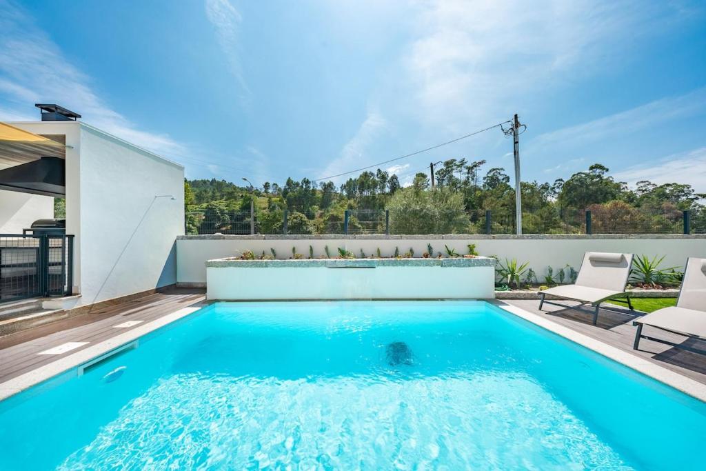 a swimming pool in the backyard of a house at Casa do primo Zeca in Ponte da Barca