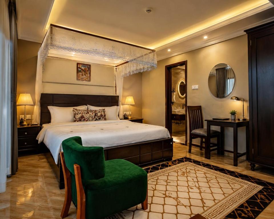 a bedroom with a large bed and a green chair at Coco Hotel Busia in Busia