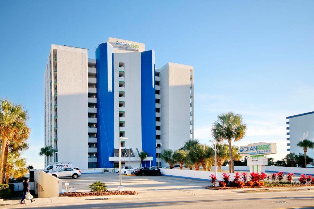 a large building with palm trees in a parking lot at Ocean Park Resort in Myrtle Beach