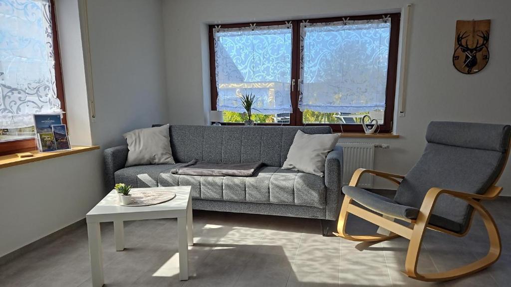 a living room with a couch and two chairs at Ferienwohnung An Der Kapelle in Rickenbach
