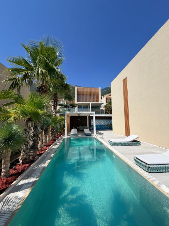 a swimming pool with palm trees next to a building at Villa Azul in Palasë