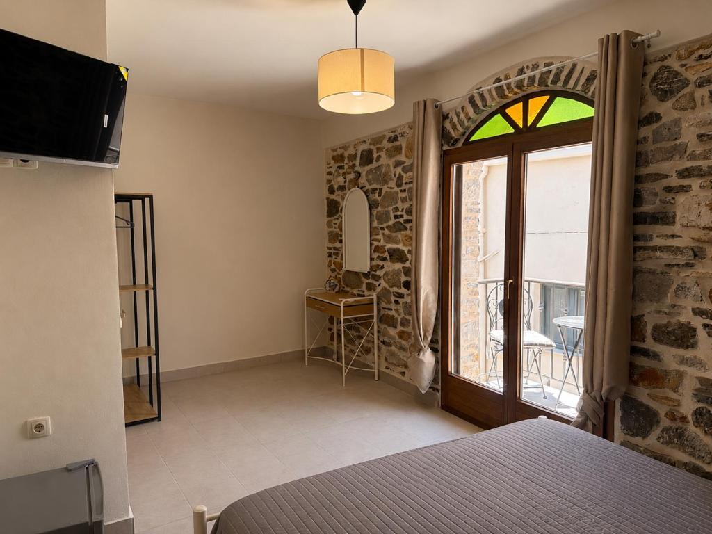 ein Schlafzimmer mit einem Bett und einem großen Fenster in der Unterkunft Mastic Nest in Chios