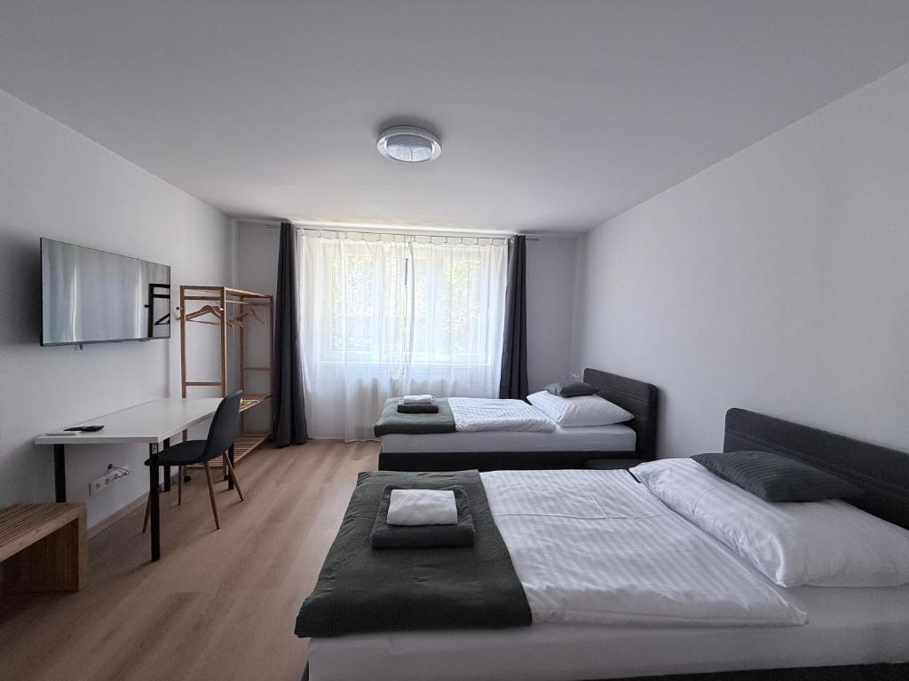 a bedroom with two beds and a desk and a table at Apartman H4 in Žilina