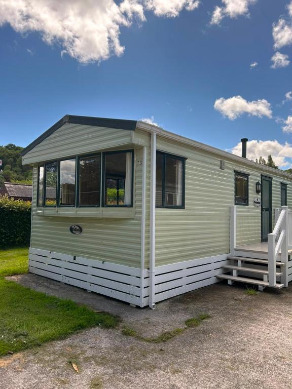 a green caravan with a porch and a lawn at 31 Mobile Home Lemon Park Devon in Bickington