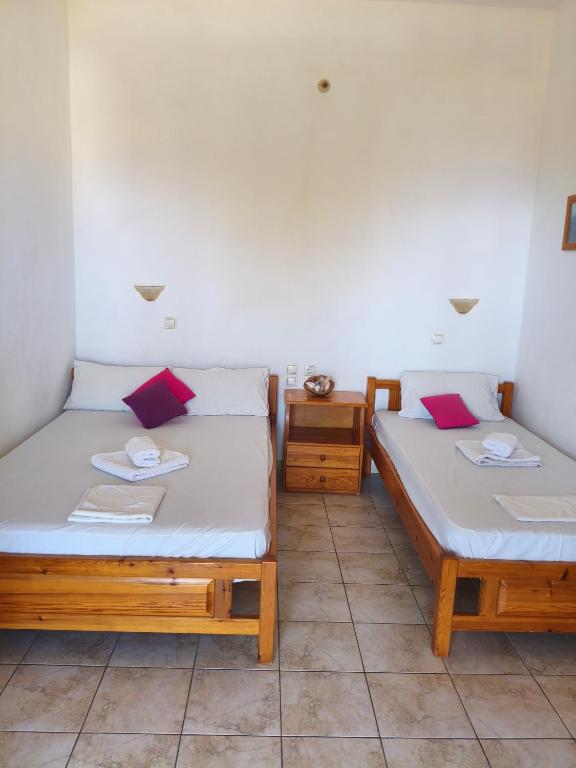 two beds in a room with two tables at studios Katerina A Lentas in Lentas