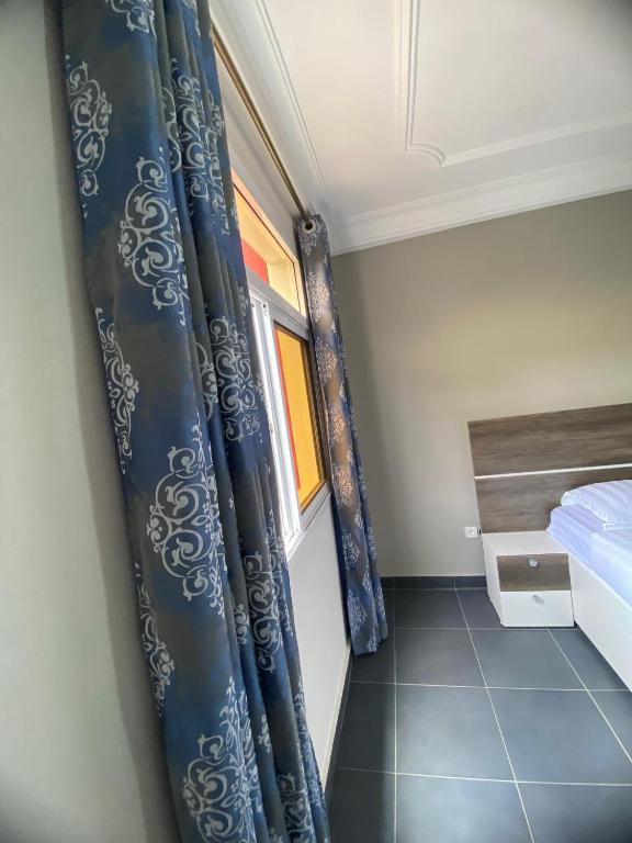 a small room with a bed and a window at Résidence les Palaja in Douala