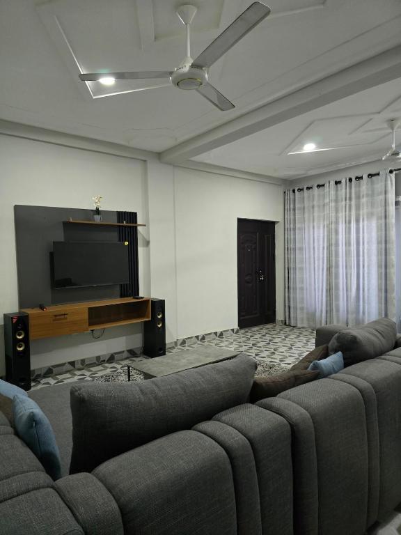 a living room with a couch and a flat screen tv at 2 bedroom super cozy apartment in Accra