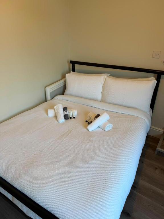 a bed with two towels and two bottles on it at Stylish Bolton Stay Parking Walk to Town Centre in Farnworth