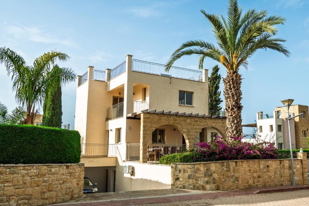 a house with a palm tree in front of it at Leda Beach Villa in Polis Chrysochous