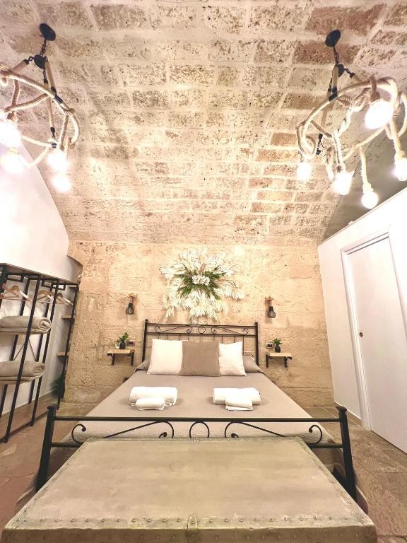 a bed in a room with a brick wall at L’Antica Dimora in Bari