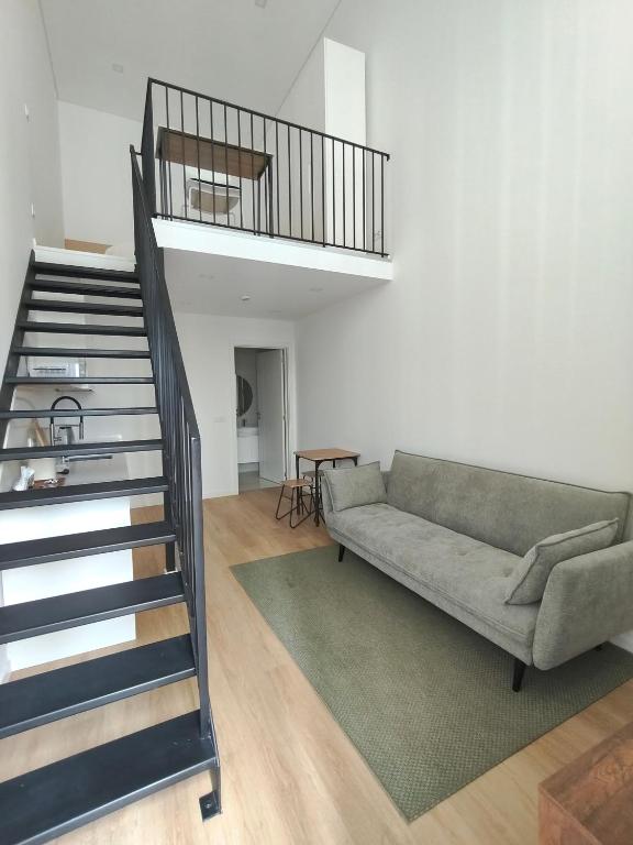 a living room with a couch and a staircase at AlvaLoft Barreiro in Barreiro