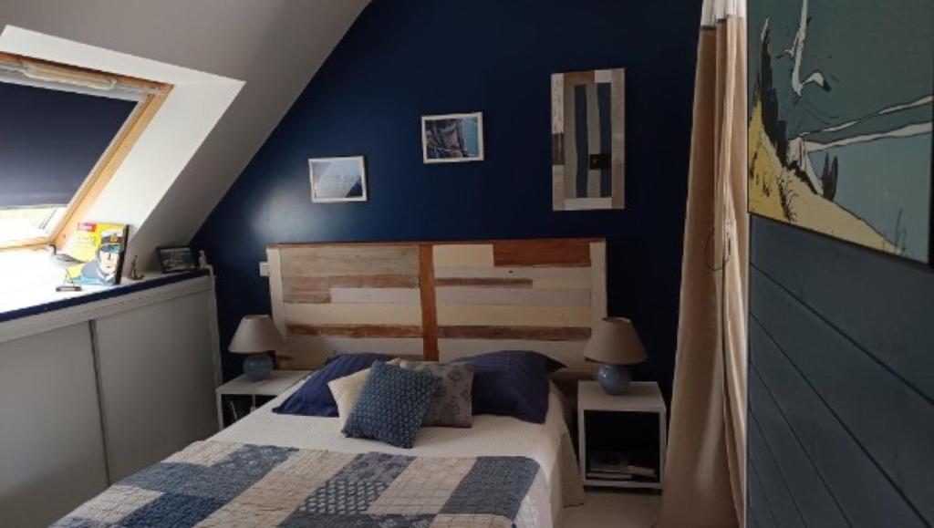 a bedroom with a bed and a blue wall at Sterne pierregarin 2kms de la plage in Séné