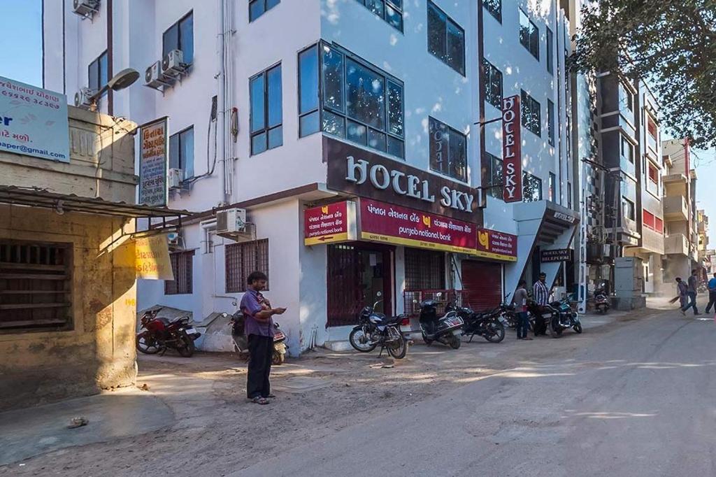 a man standing in the street in front of a building at Hotel Sky in Dwarka