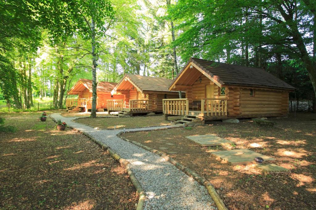 a log cabin in the woods with a path in front at Chambres d'hôtes La Gargaille in Alièze