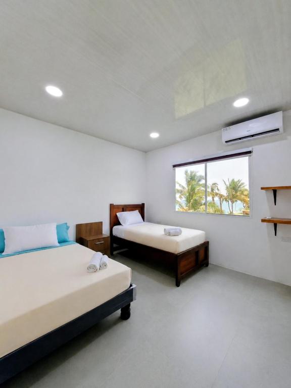 a bedroom with two beds and a window at Suite Meridiano Direct Beach Access y AC in Ballenita