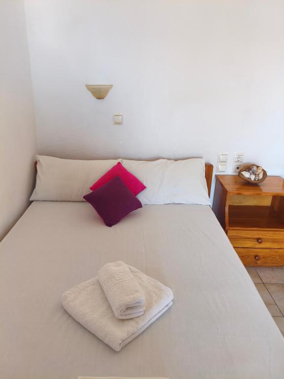 a bedroom with a white bed with a towel on it at Katerina studios D Lentas in Lentas