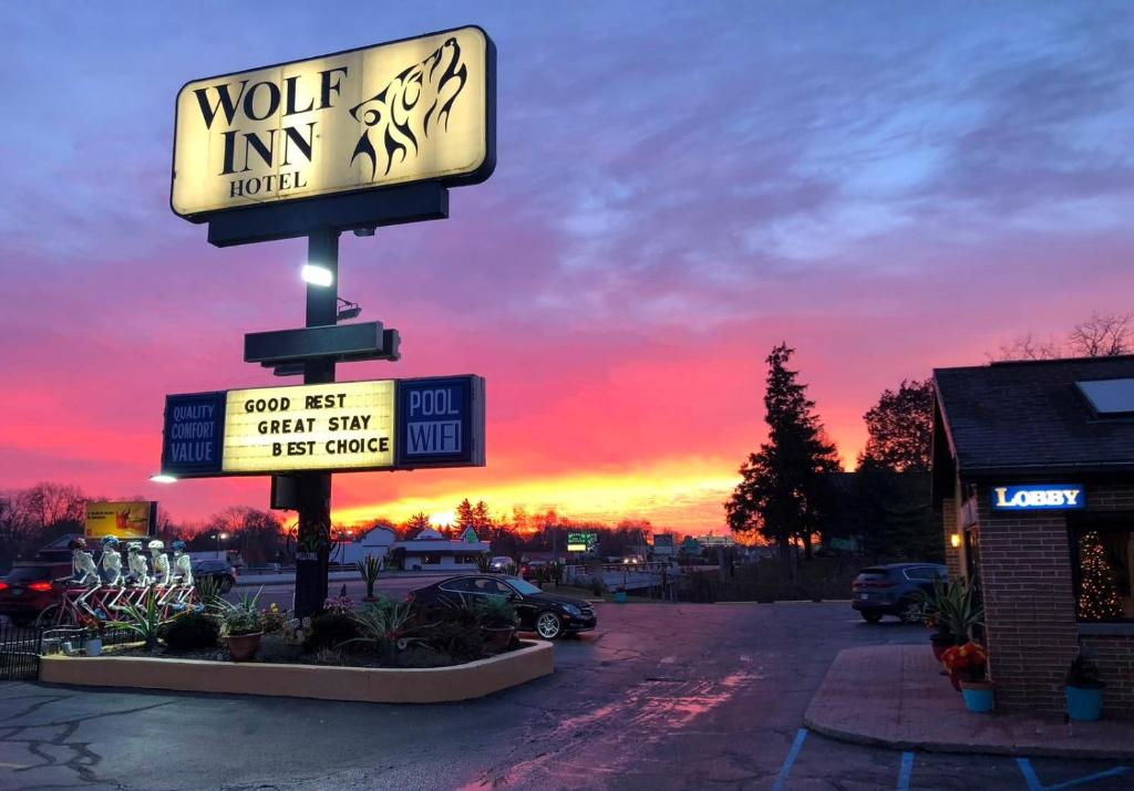 a sign for a vote inn motel with a sunset in the background at Wolf Inn Hotel in Sandusky