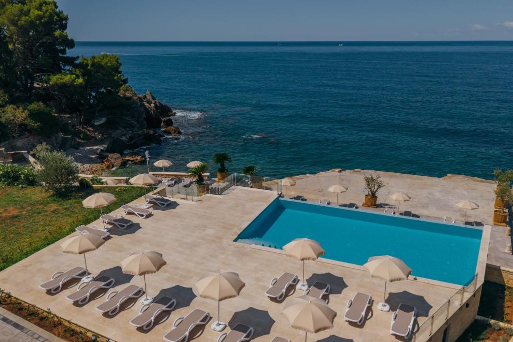 an image of a swimming pool with chairs and umbrellas at Zelen LUX in Sutomore