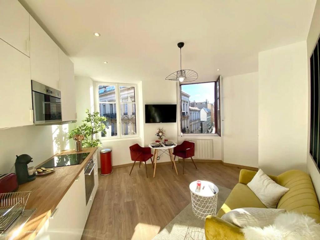a living room with a couch and a table at Le Vivaldi - Studio Hypercentre Saint-Étienne in Saint-Étienne