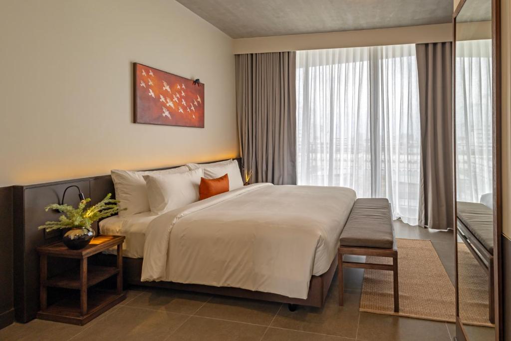 a hotel room with a large bed and a window at Prano Hotel in Bangkok