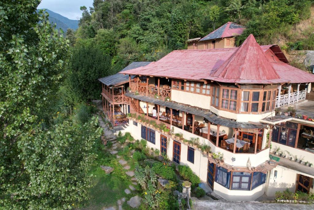 an aerial view of a large house with a red roof at Orchard Huts in Chamba
