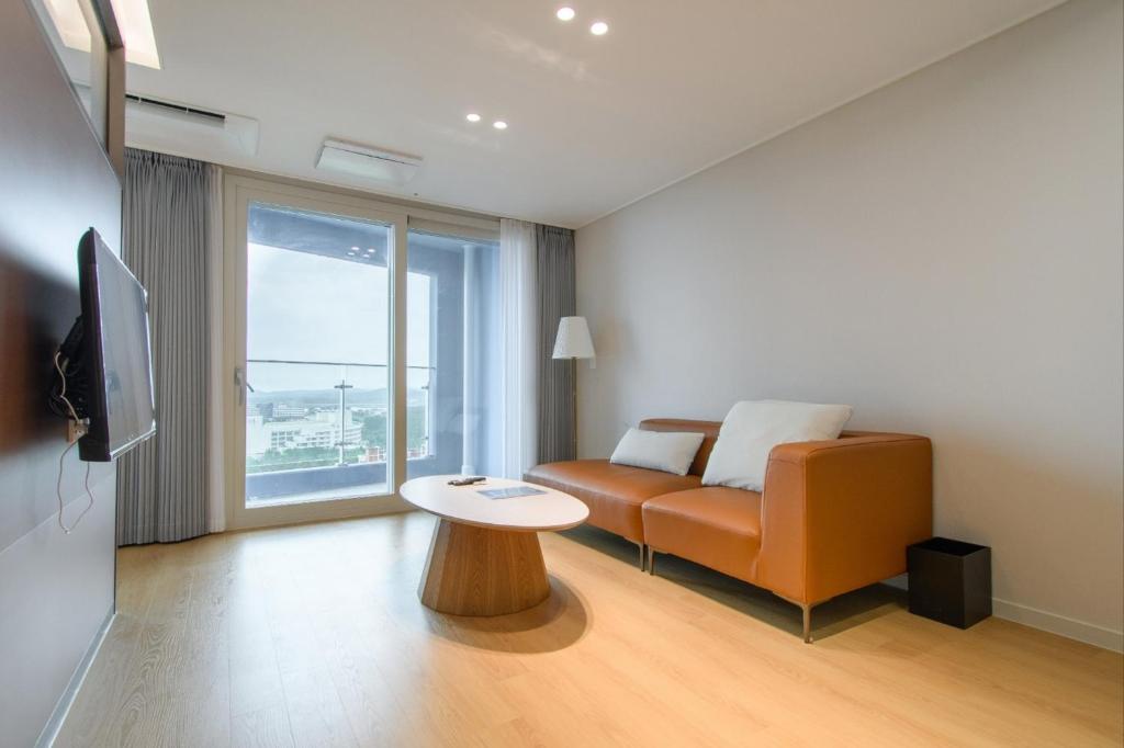 a living room with a couch and a table at 플럼바고올스위트1107 in Chosan-ni