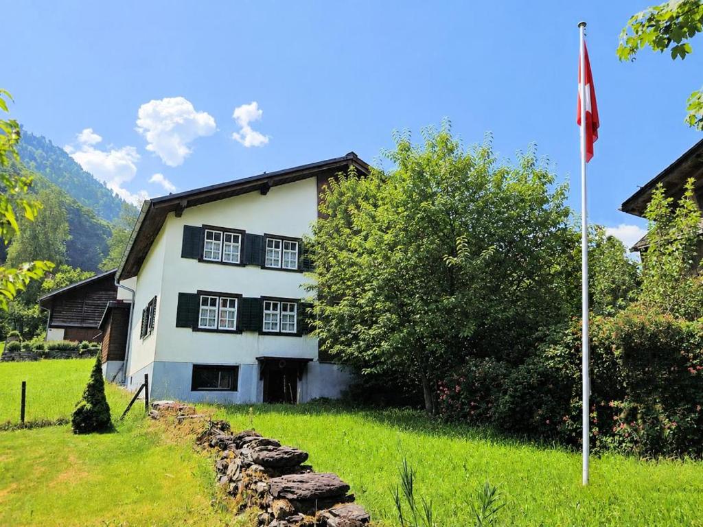 a white house with a flag in front of it at Revier Dorfidyll 1864 in Hätzingen