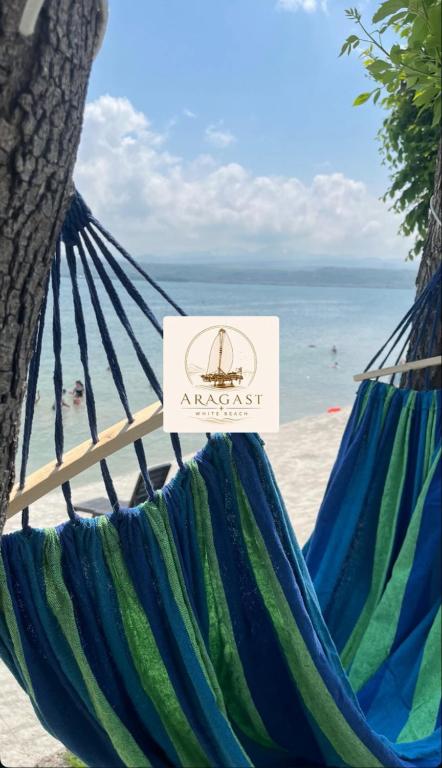 a hammock on the beach with a nautical sign at Aragast White Beach in Sevan