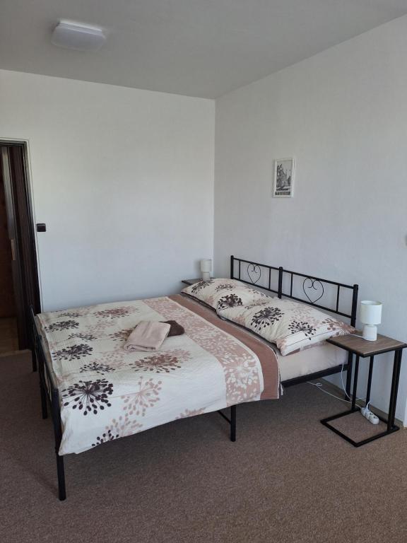 a bedroom with two beds and a side table at Apartmán Jan in Břeclav