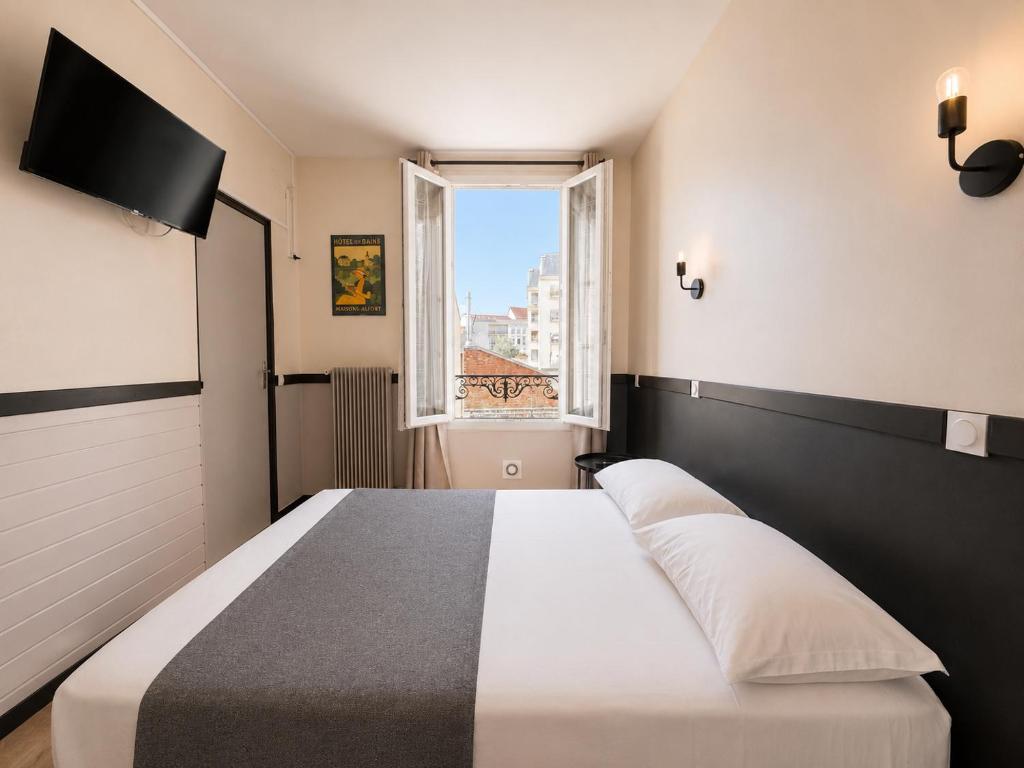 a bedroom with a bed and a window at Hôtel des Bains 24h 7j Paris centre à 10 min in Maisons-Alfort