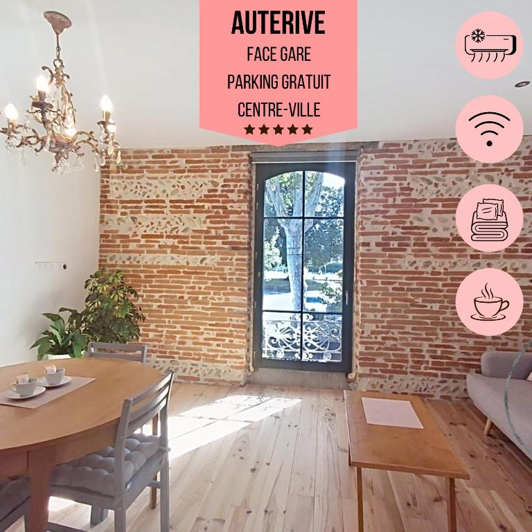 a living room with a table and a brick wall at Evasions-Dérobade, centre-ville, gare in Auterive