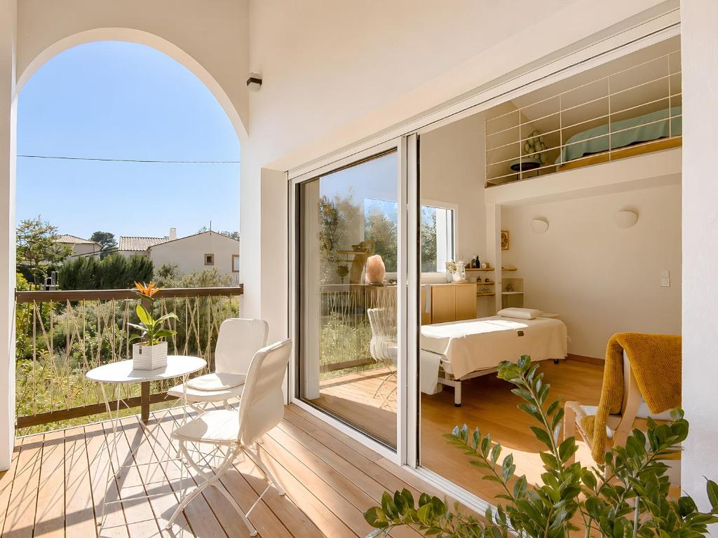 a room with a balcony with a table and chairs at Studio "Bulle de Sainte-Baume" in Plan dʼAups