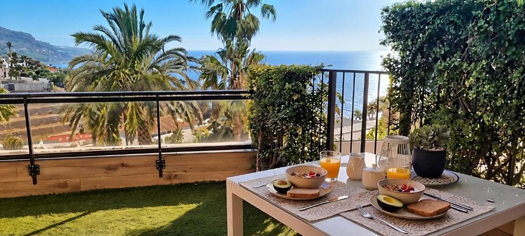 a table with food and drinks on top of a balcony at Maresía Village in Los Realejos
