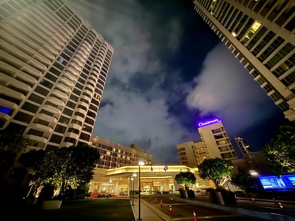 a city street with tall buildings at night at The Crescat Suite by Cinnamon Grand in Colombo