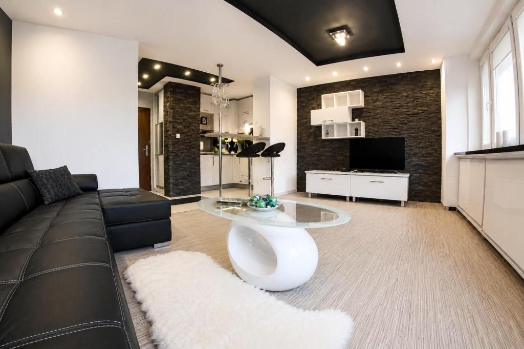 a living room with a couch and a table at Black & White Komfortowe Apartamenty 2 km od Centrum in Racibórz