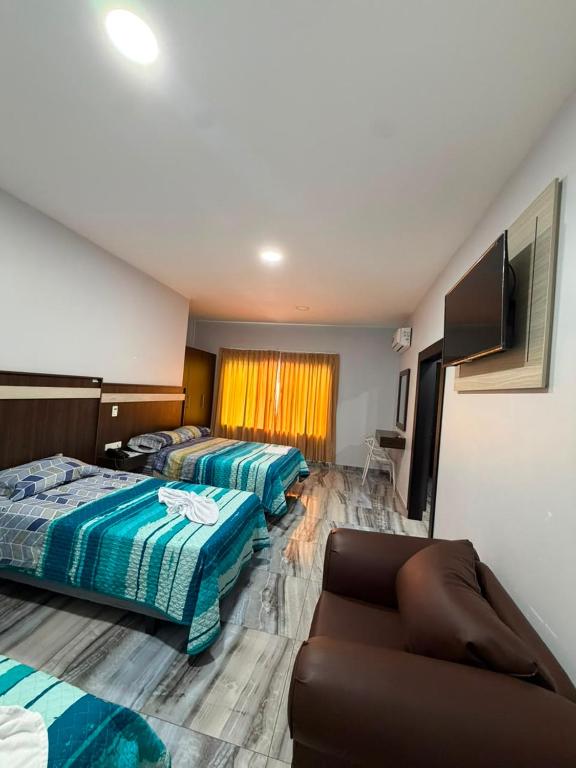 a hotel room with two beds and a couch at Hotel Imperial in Santo Domingo de los Colorados