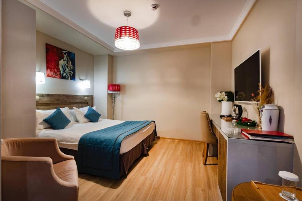 a hotel room with a bed and a desk at Luna Hotel Astana in Astana