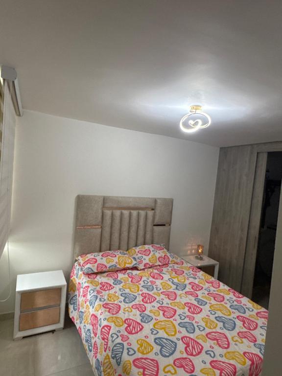 a bedroom with a bed with a colorful bedspread at Apto en el sur de cali in Cali