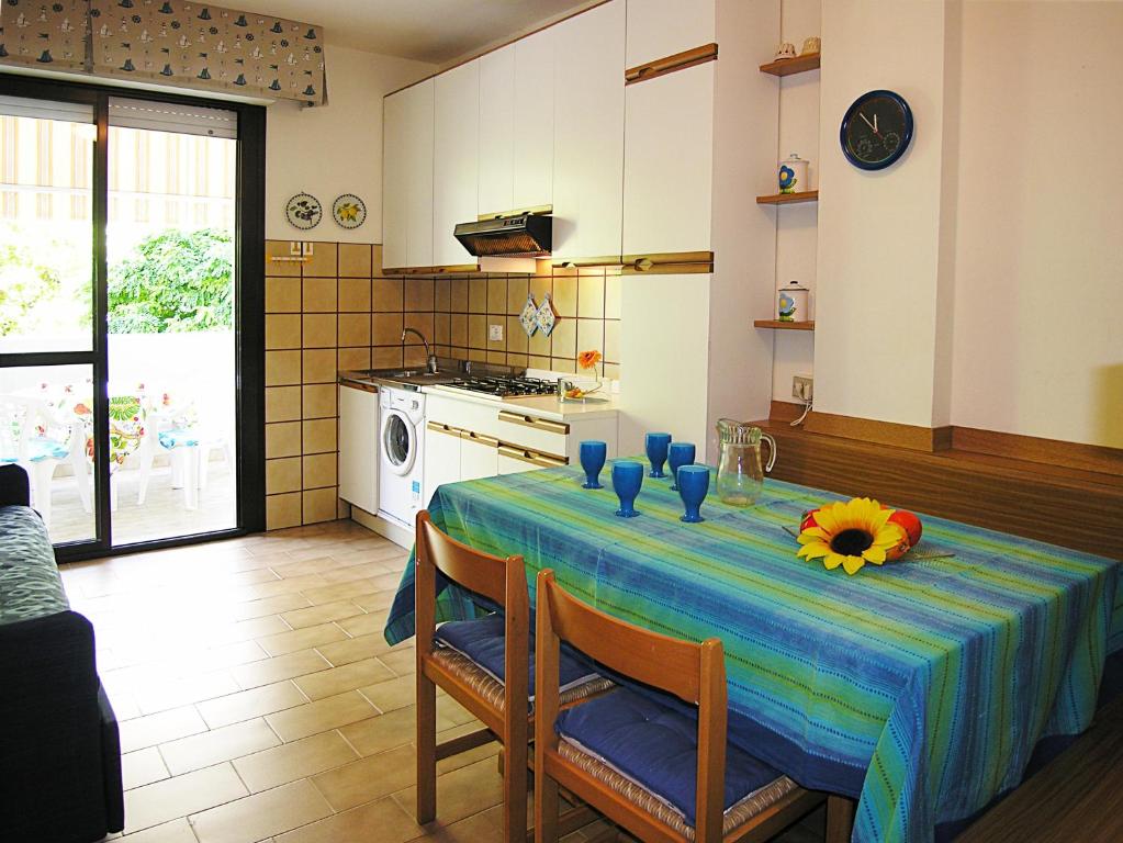 a kitchen with a table with a flower on it at Appartamenti Nasse in Bibione