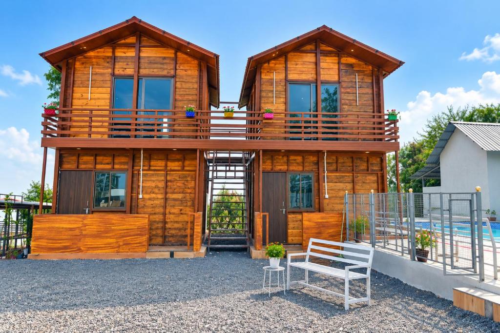 a wooden house with a bench in front of it at Royal Shouryas Resort in Kolhapur