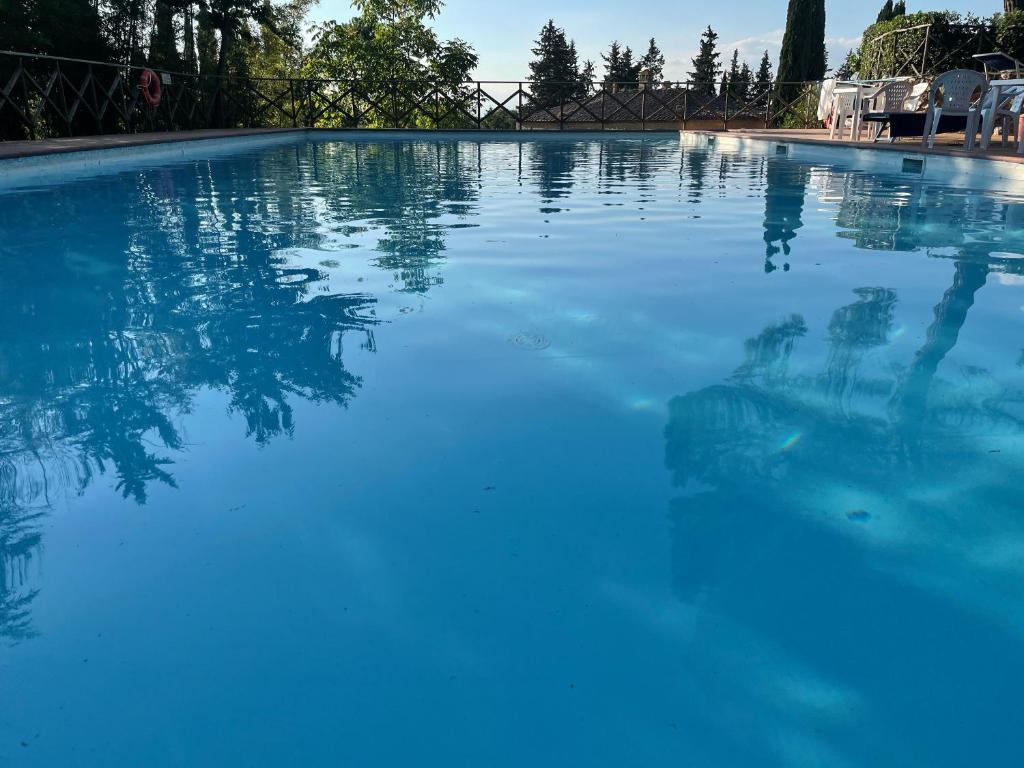 a pool of blue water with a person in it at Castel Pietraio WineResort in Monteriggioni