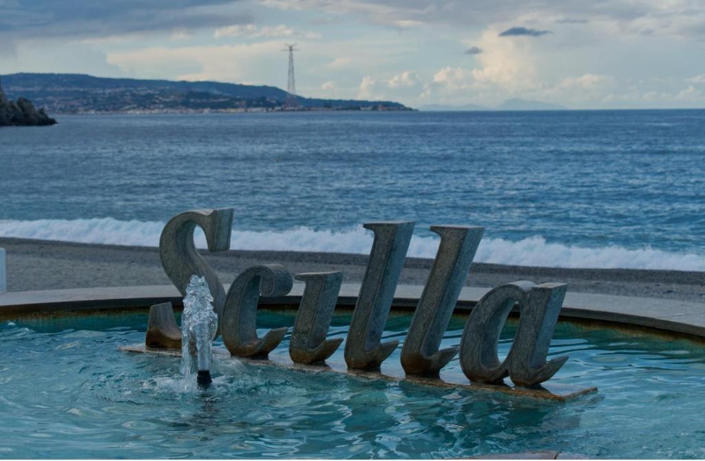 a water fountain in front of the ocean at Aura in Scilla
