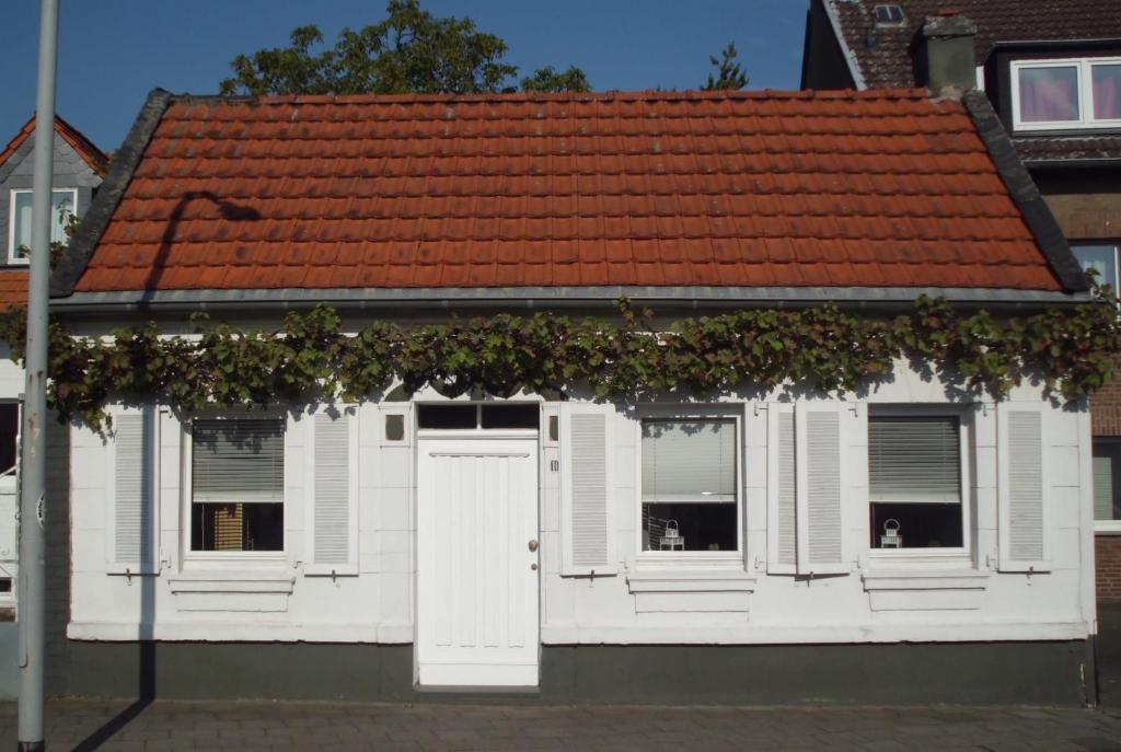 メンヒェングラートバッハにあるKleines, gemütliches Häuschenのオレンジ色の屋根の白い家