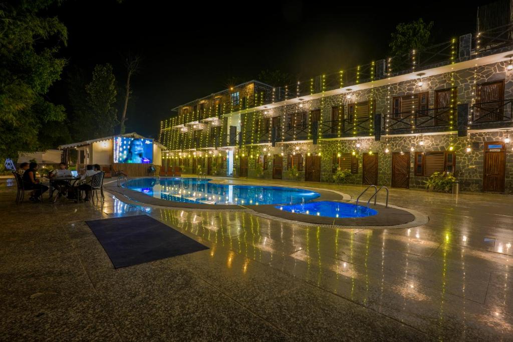 a building with a fountain in front of it at night at The Ashoka Tiger in Dhikala Zone