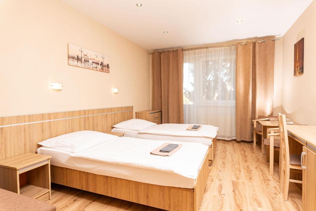 a hospital room with two beds and a table at Penzión ORION in Prievidza